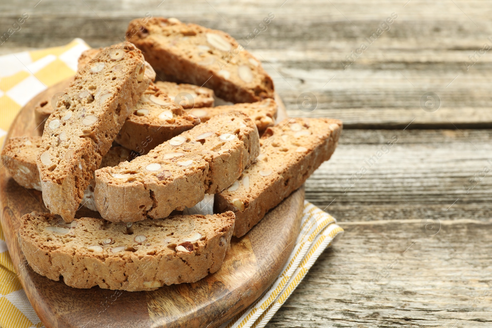 Photo of Traditional Italian almond biscuits (Cantucci) on wooden table, closeup. Space for text