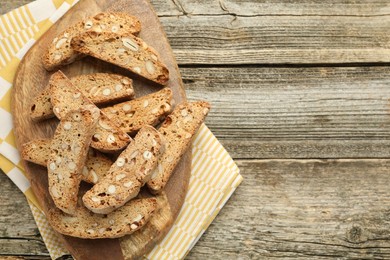 Photo of Traditional Italian almond biscuits (Cantucci) on wooden table, top view. Space for text