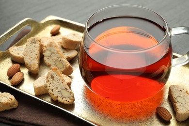 Traditional Italian almond biscuits (Cantucci), nuts and cup of tea on grey table, closeup