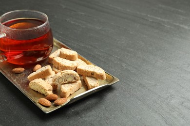 Traditional Italian almond biscuits (Cantucci) and cup of tea on grey textured table. Space for text