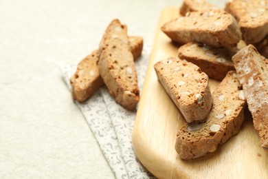 Photo of Traditional Italian almond biscuits (Cantucci) on light textured table, closeup. Space for text