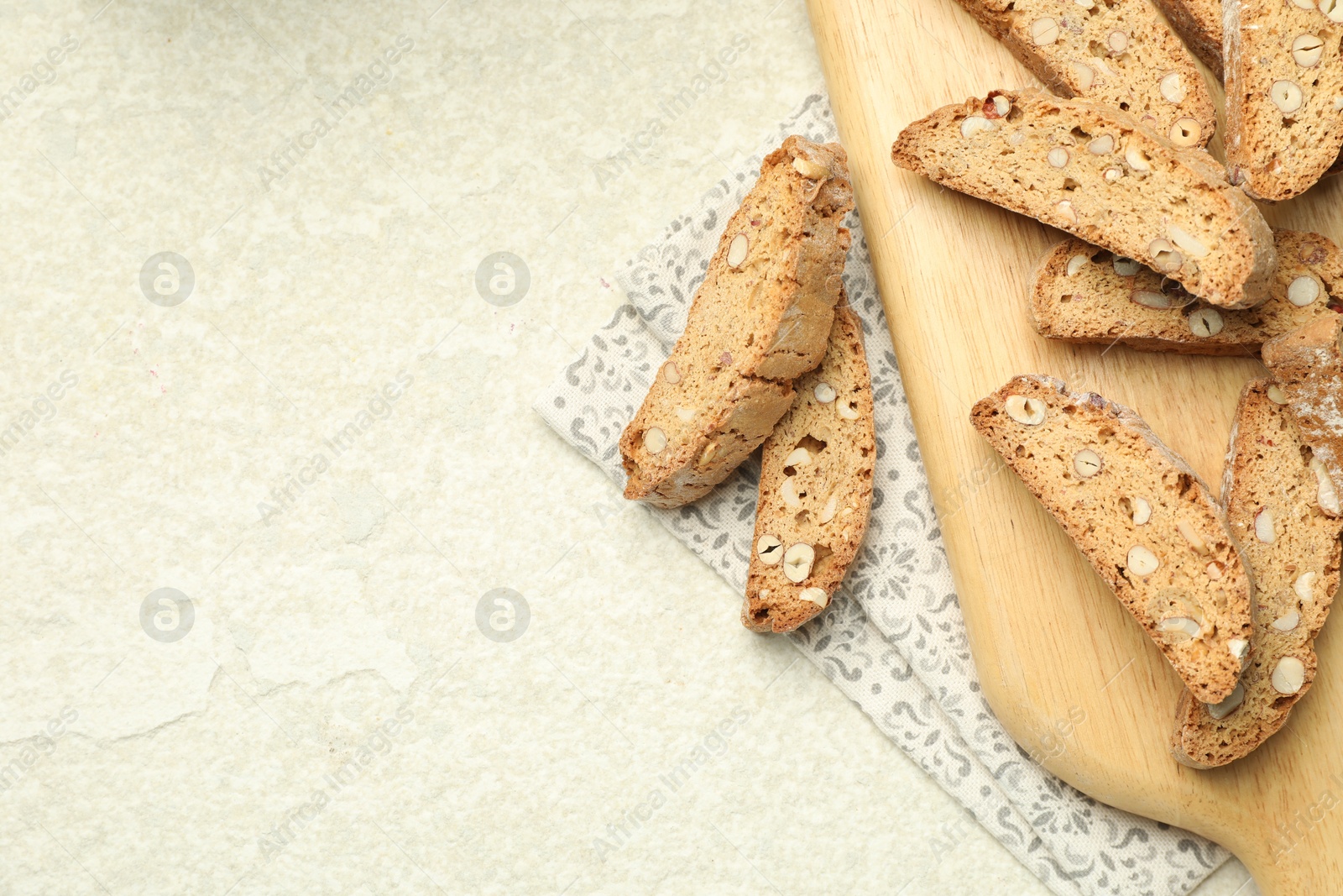 Photo of Traditional Italian almond biscuits (Cantucci) on light textured table, flat lay. Space for text