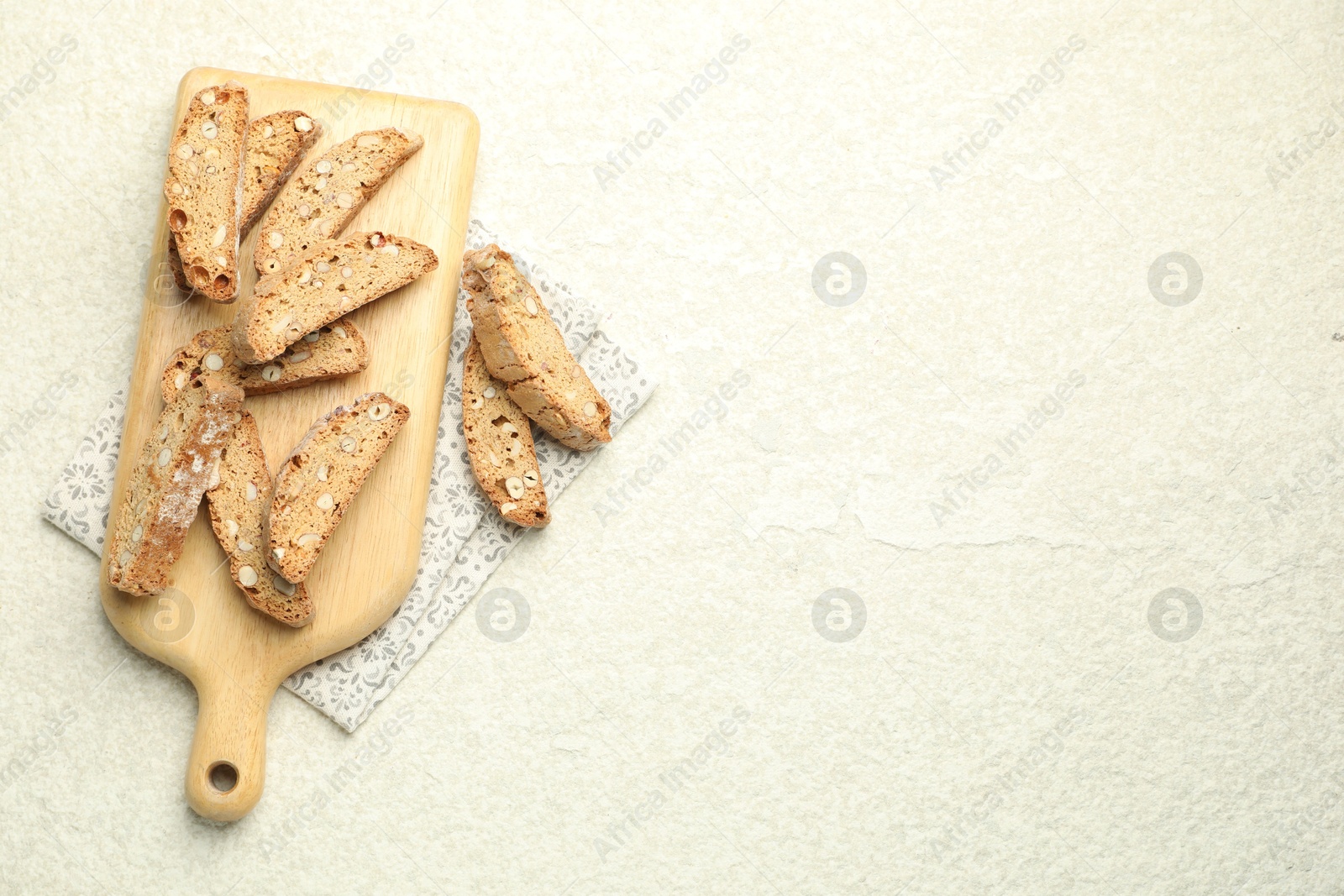 Photo of Traditional Italian almond biscuits (Cantucci) on light textured table, flat lay. Space for text