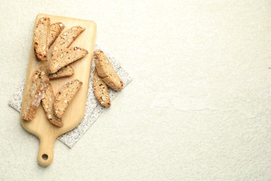 Photo of Traditional Italian almond biscuits (Cantucci) on light textured table, flat lay. Space for text