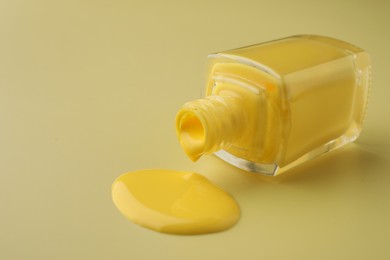 Photo of Bottle of nail polish on yellow background, closeup