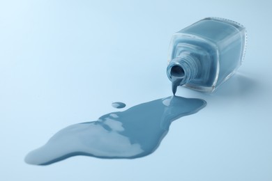 Photo of Bottle of nail polish on light blue background, closeup