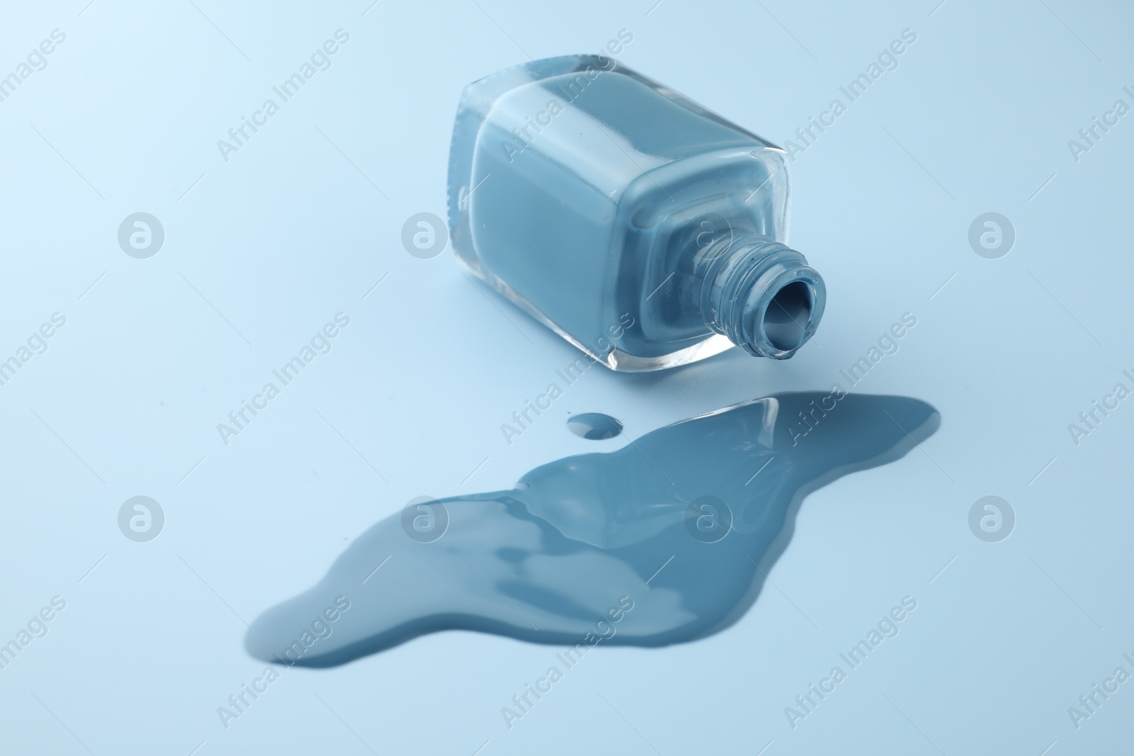 Photo of Bottle of nail polish on light blue background, closeup