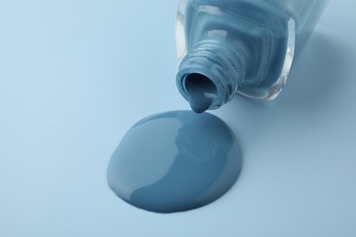 Photo of Bottle of nail polish on light blue background, closeup