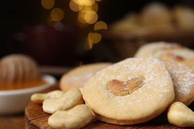 Photo of Tasty cashew cookies with powdered sugar on table, closeup. Space for text