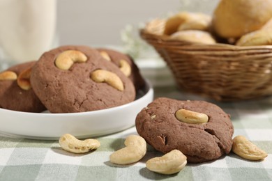 Photo of Tasty chocolate cookies with cashew on table, closeup