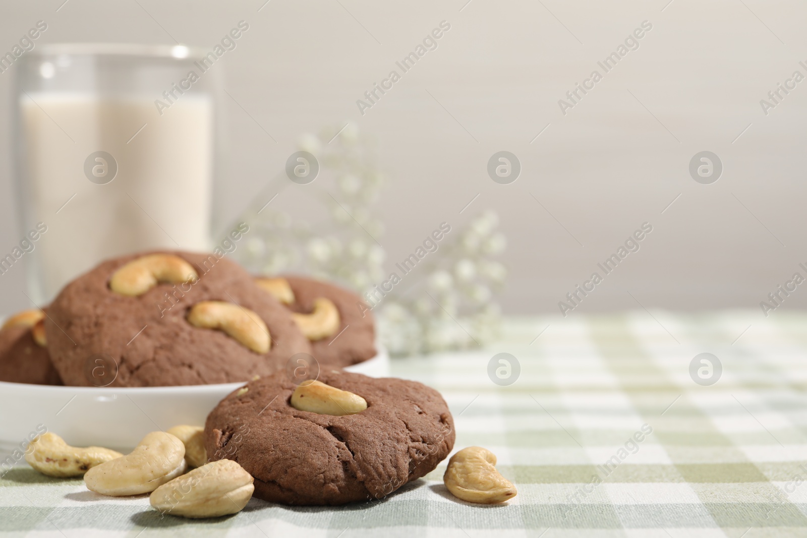 Photo of Tasty chocolate cookies with cashew on table, closeup. Space for text