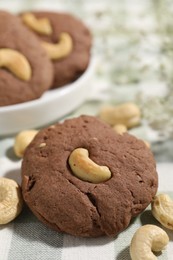 Photo of Tasty chocolate cookies with cashew on table, closeup