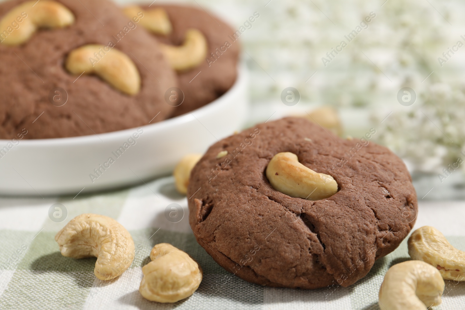 Photo of Tasty chocolate cookies with cashew on table, closeup