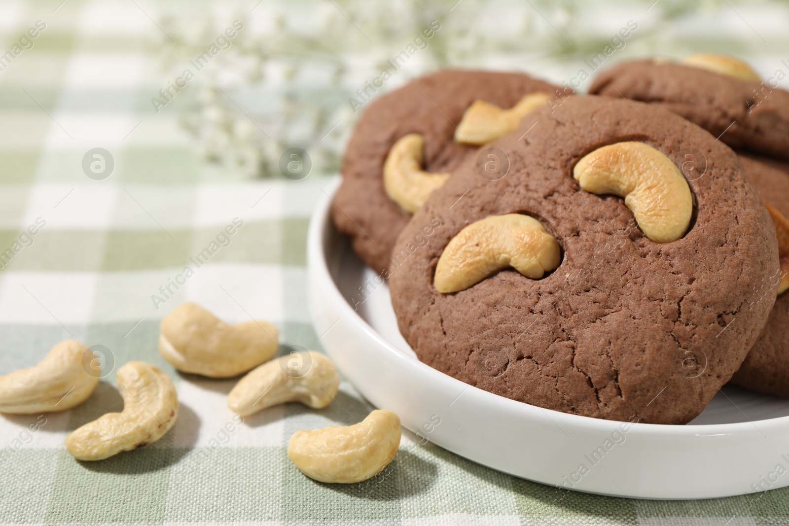 Photo of Tasty chocolate cookies with cashew on table, closeup