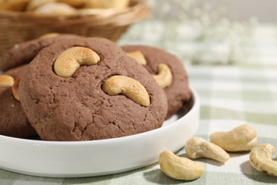 Photo of Tasty chocolate cookies with cashew on table, closeup