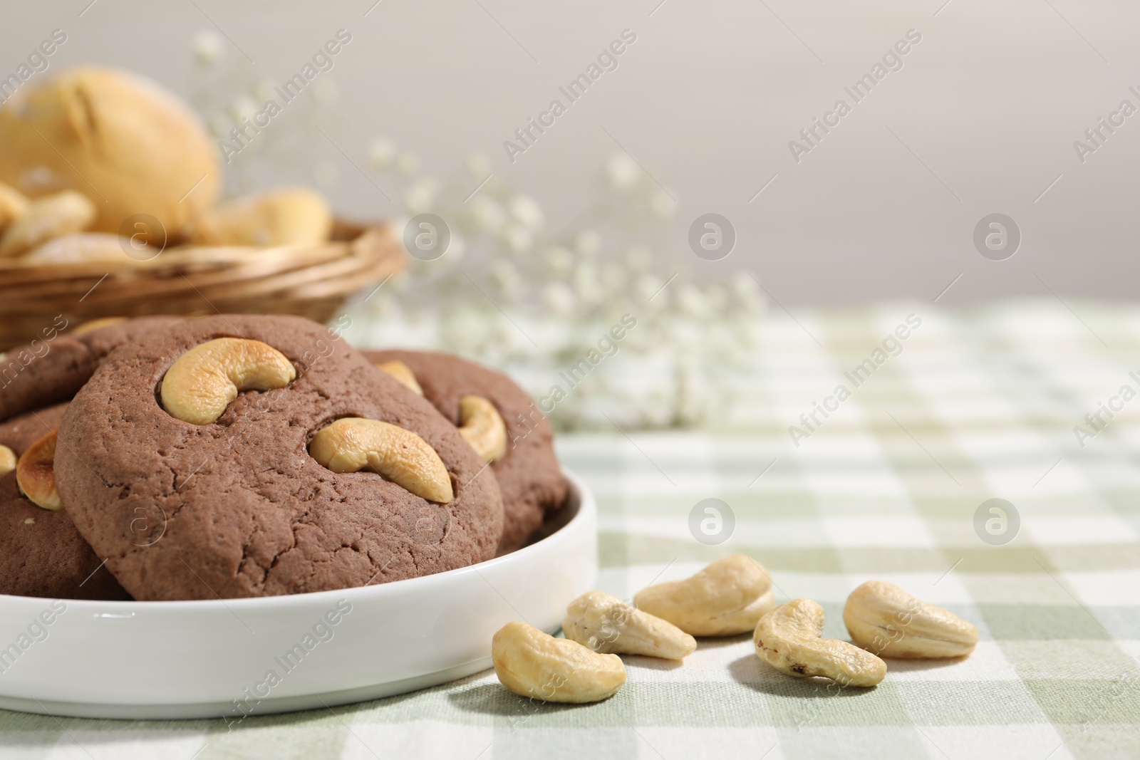 Photo of Tasty chocolate cookies with cashew on table, closeup. Space for text