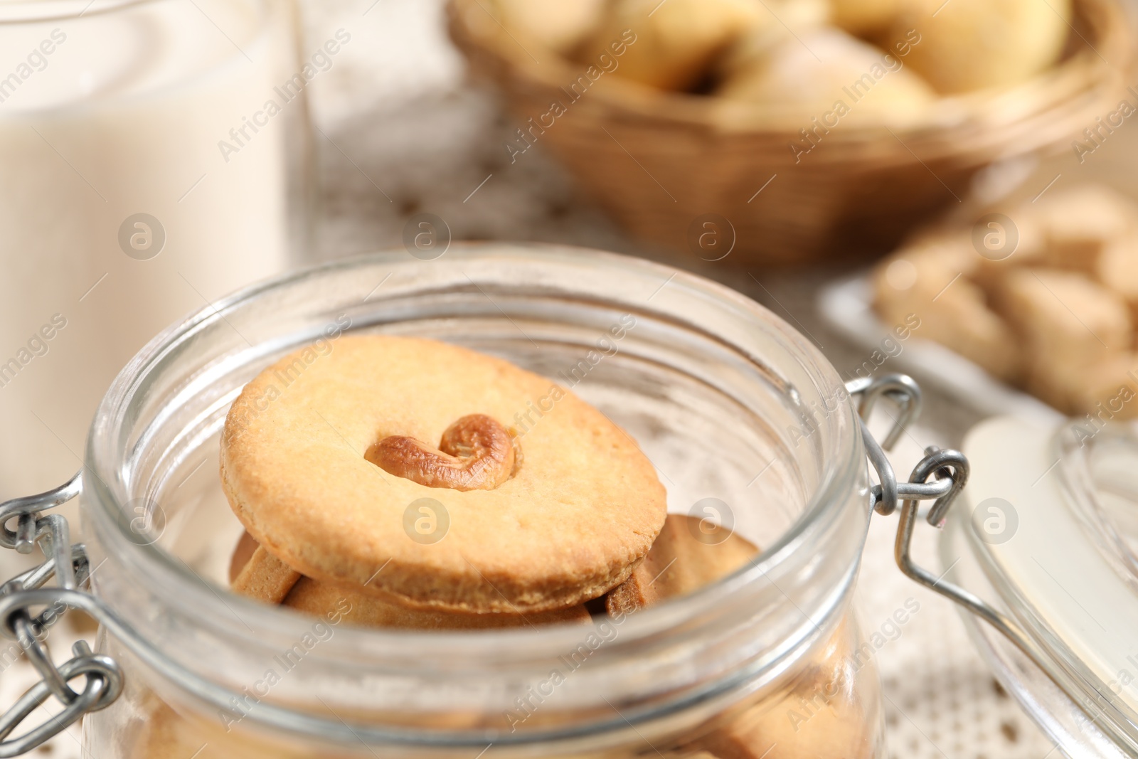 Photo of Tasty cashew cookies in jar on table, closeup