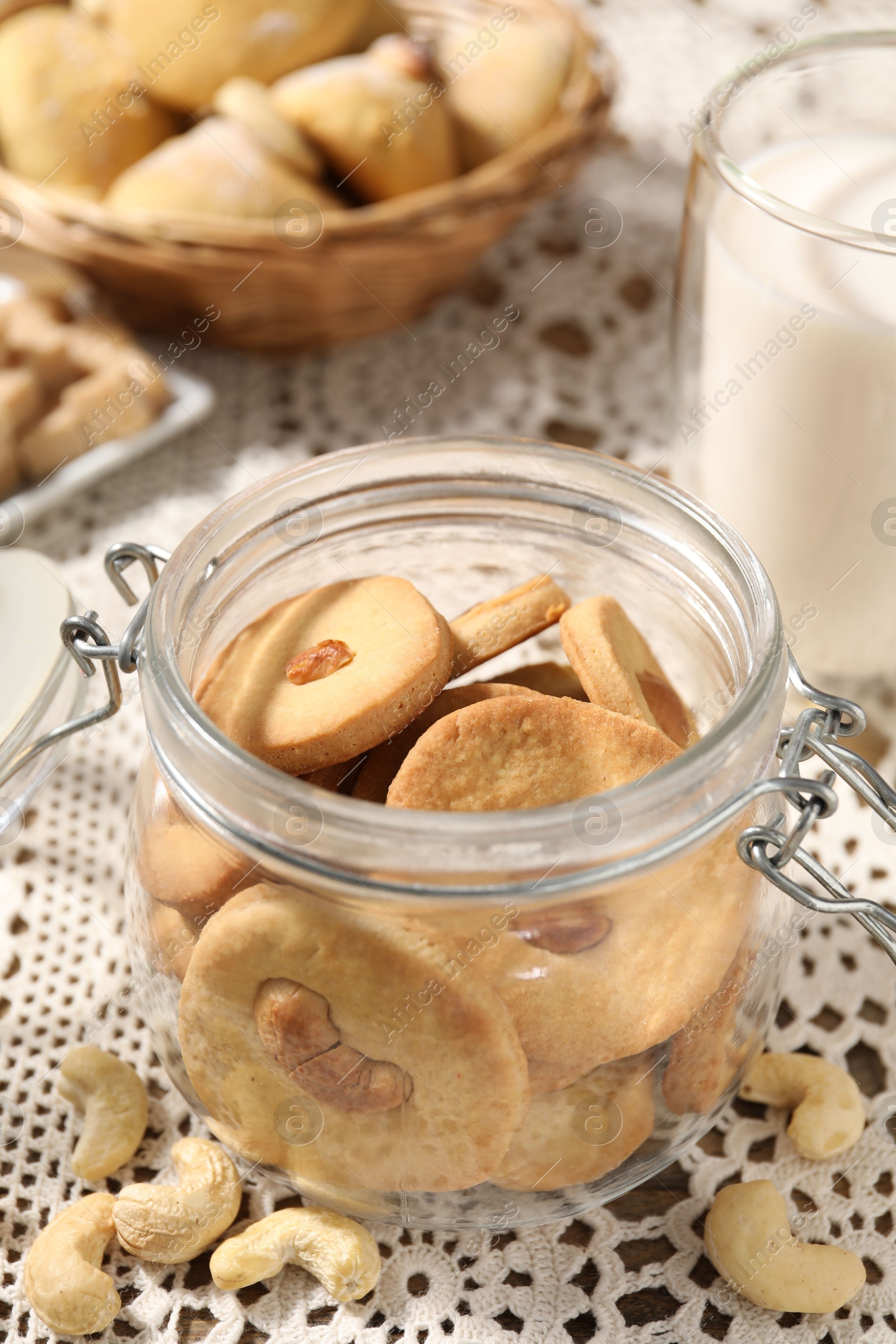 Photo of Tasty cashew cookies in jar on table, closeup