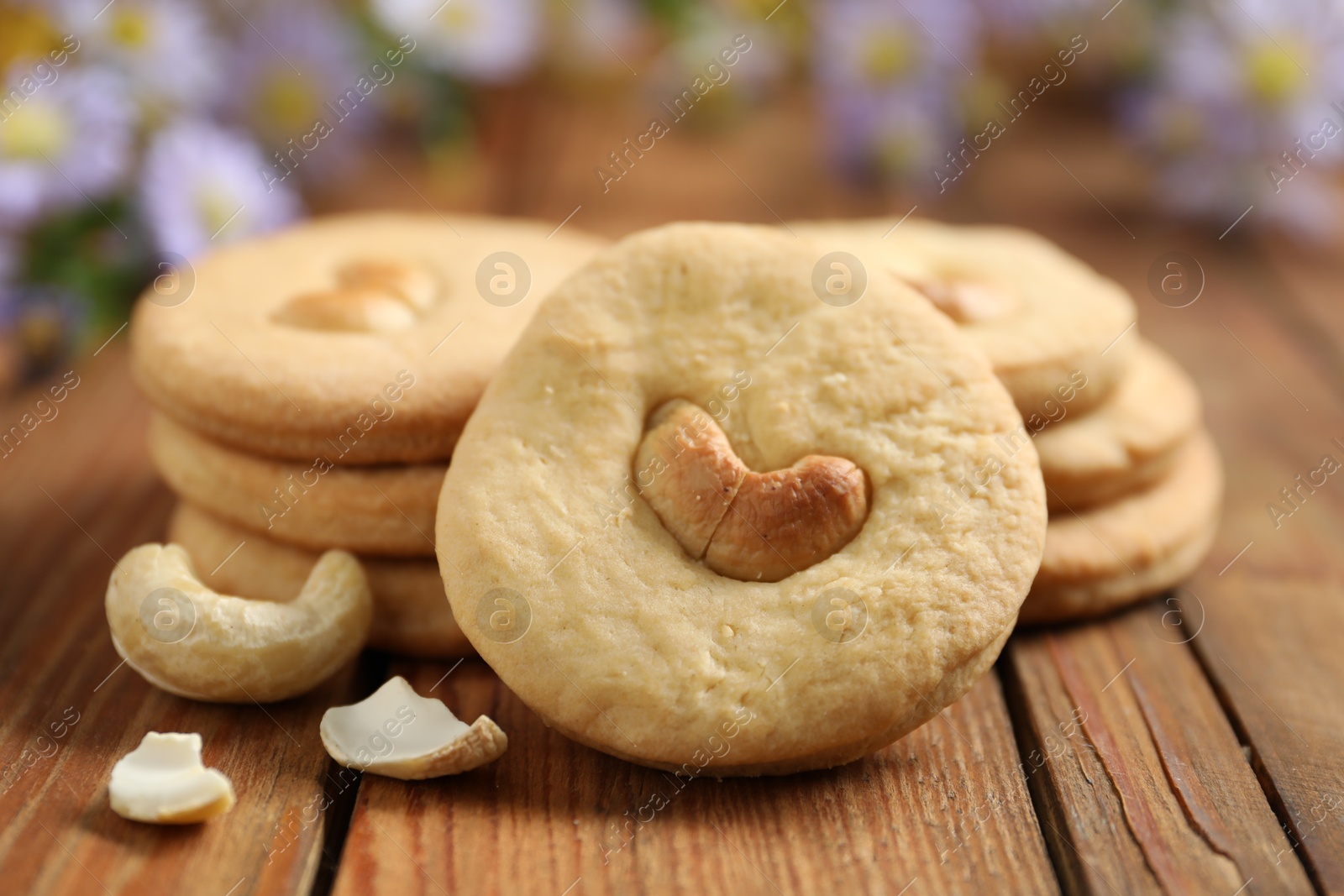 Photo of Tasty cashew cookies on wooden table, closeup