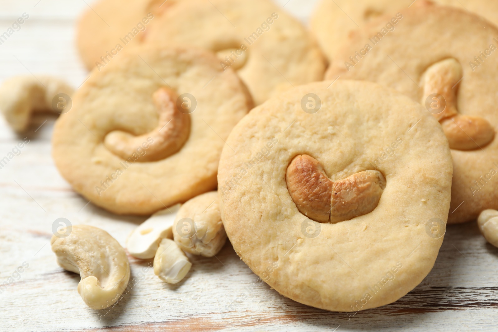 Photo of Tasty cashew cookies on rustic wooden table, closeup