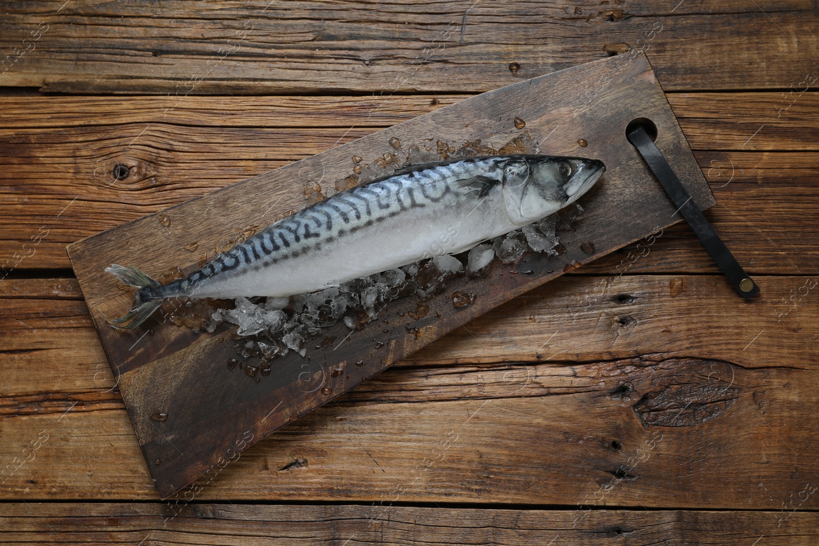 Photo of Frozen mackerel fish on wooden table, top view