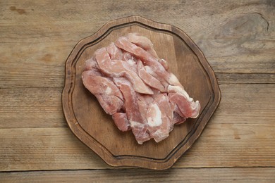 Photo of Frozen pieces of chicken fillet on wooden table, top view