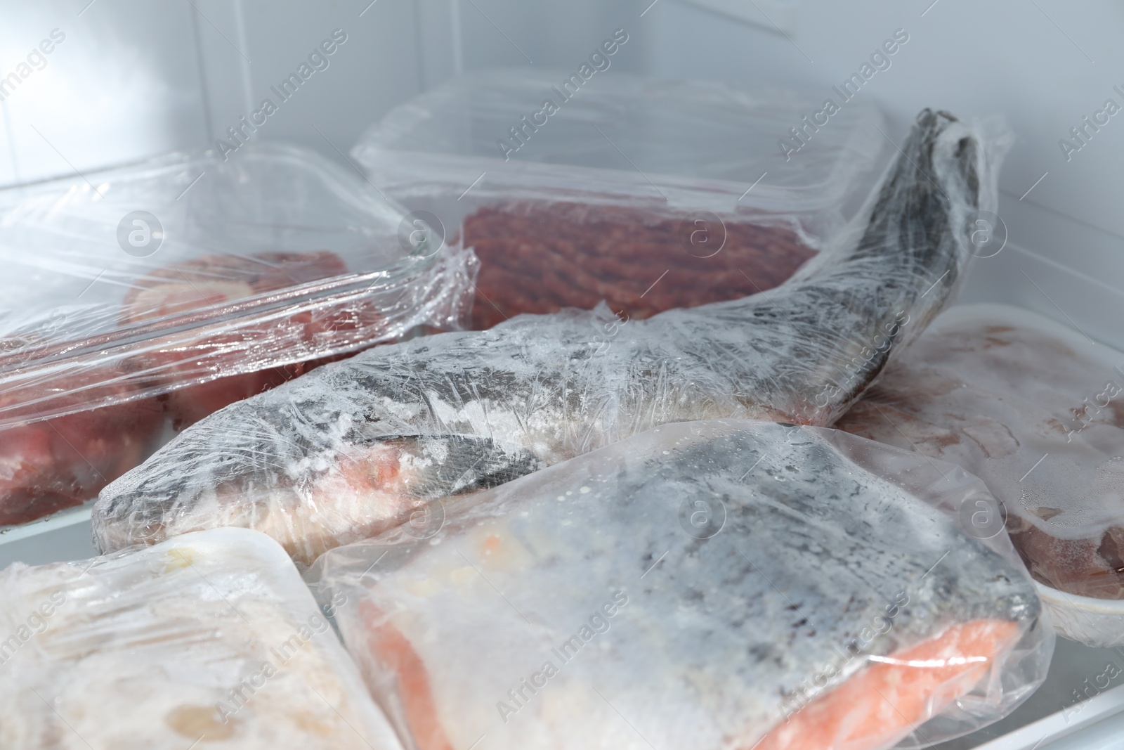 Photo of Different frozen meat and fish products on refrigerator shelf, closeup