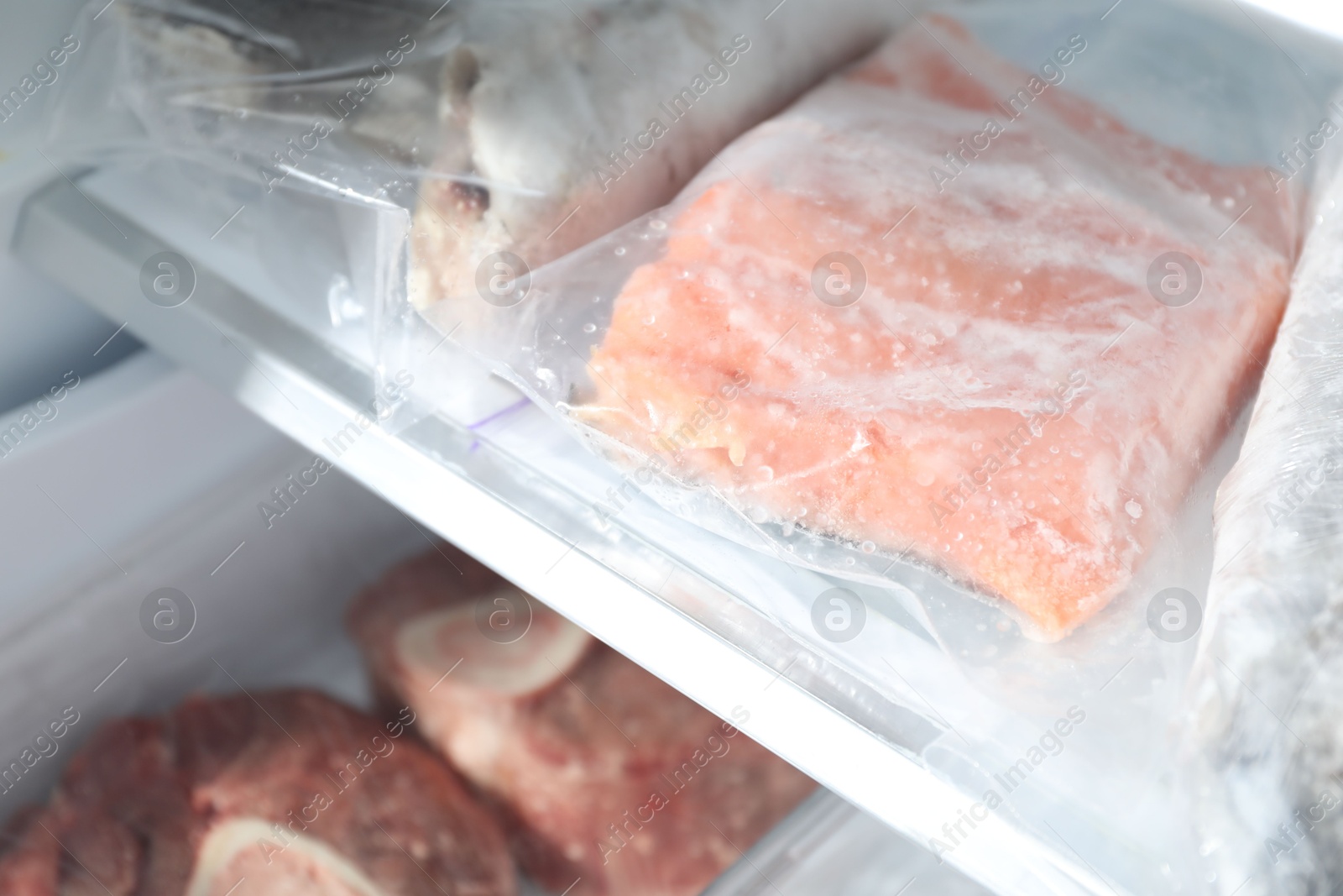 Photo of Different frozen meat and fish products on refrigerator shelf, closeup