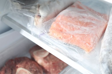 Photo of Different frozen meat and fish products on refrigerator shelf, closeup