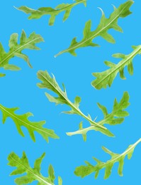 Image of Fresh green arugula in air on light blue background