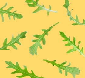 Image of Fresh green arugula in air on light orange background