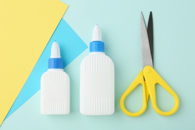 Photo of Glue, colorful paper and scissors on turquoise background, flat lay