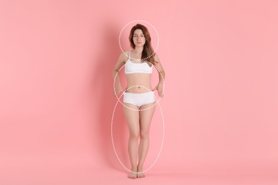 Image of Beautiful young woman in underwear posing on pink background. Dashed lines around her slim body