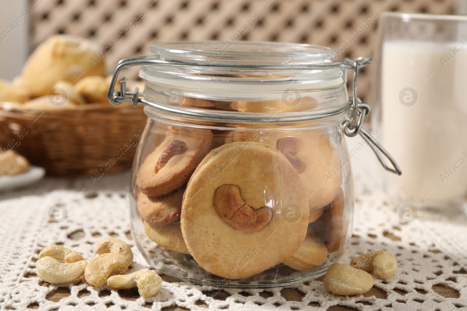 Photo of Tasty cashew cookies in jar on table, closeup