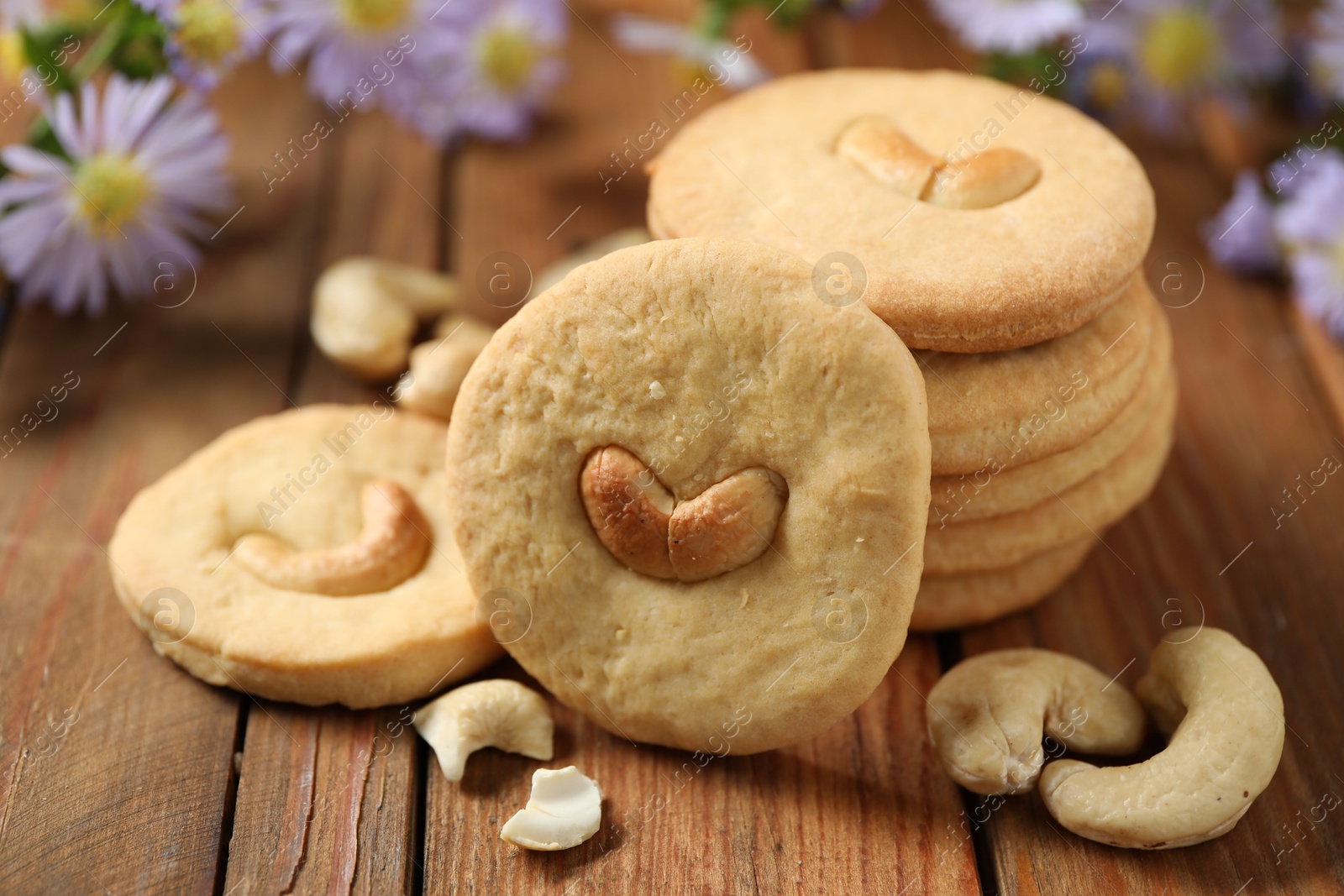 Photo of Tasty cashew cookies on wooden table, closeup