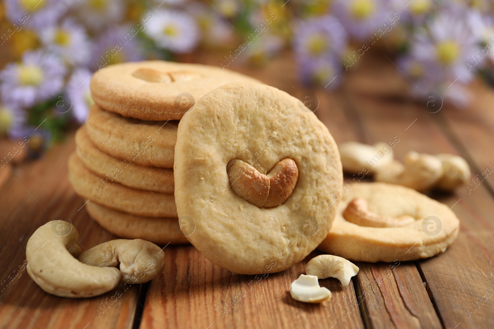 Photo of Tasty cashew cookies on wooden table, closeup