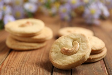 Photo of Tasty cashew cookies on wooden table, closeup