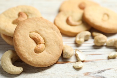 Photo of Tasty cashew cookies on rustic wooden table, closeup