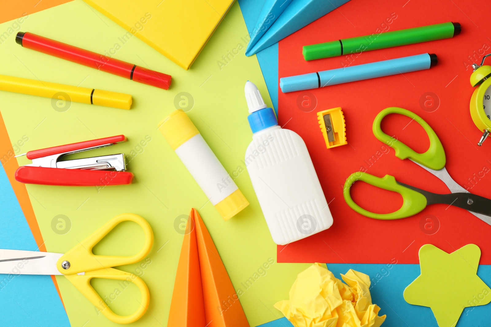 Photo of Flat lay composition with glue, scissors and other stationery on color background