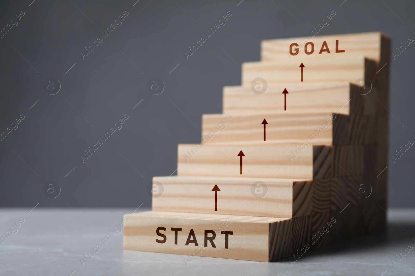 Image of Stair of wooden blocks with words Start and Goal on at beginning and at end. Steps to success concept