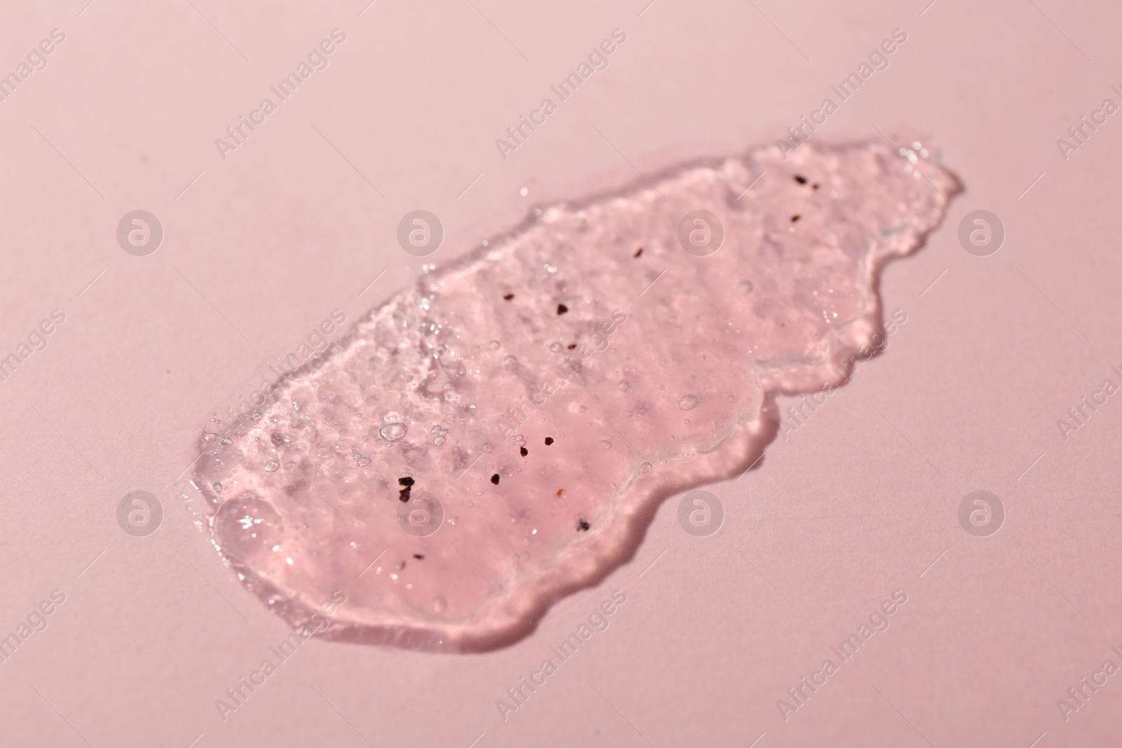 Photo of Smear of body scrub on light pink background, top view