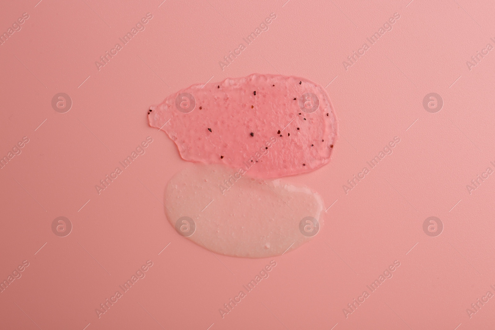 Photo of Smears of body scrubs on light pink background, top view