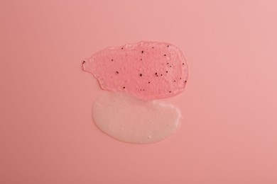 Smears of body scrubs on light pink background, top view