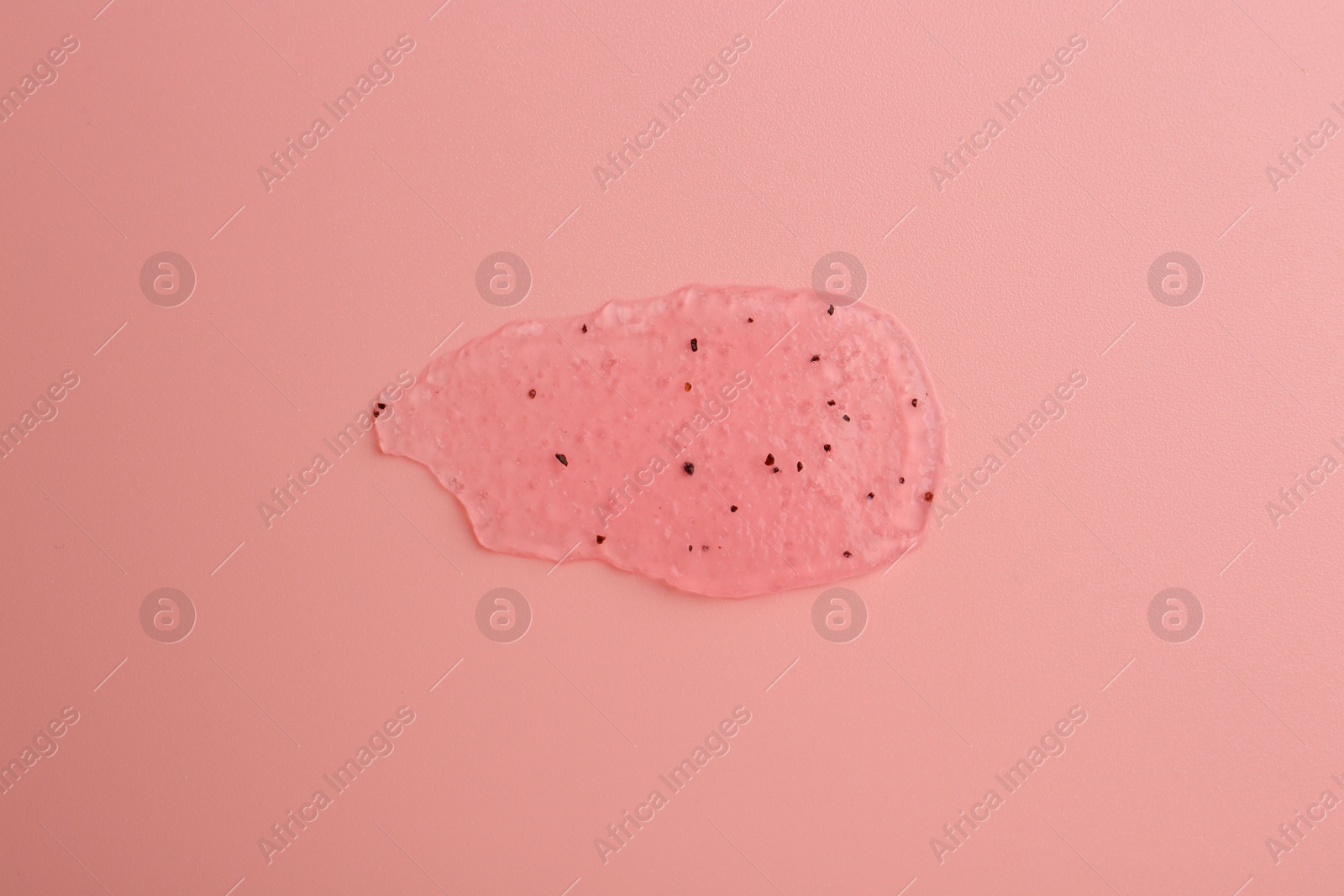 Photo of Smear of body scrub on light pink background, top view