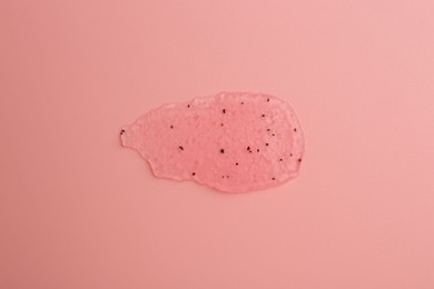 Photo of Smear of body scrub on light pink background, top view