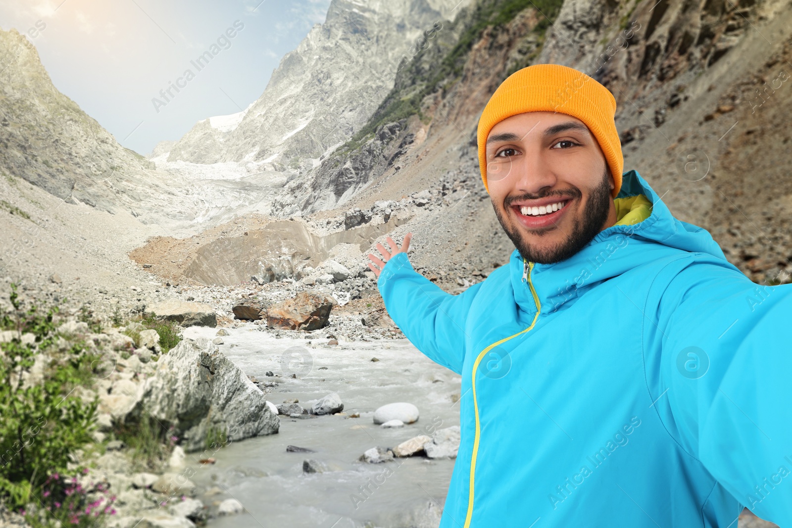 Image of Happy man in hat taking selfie in mountains