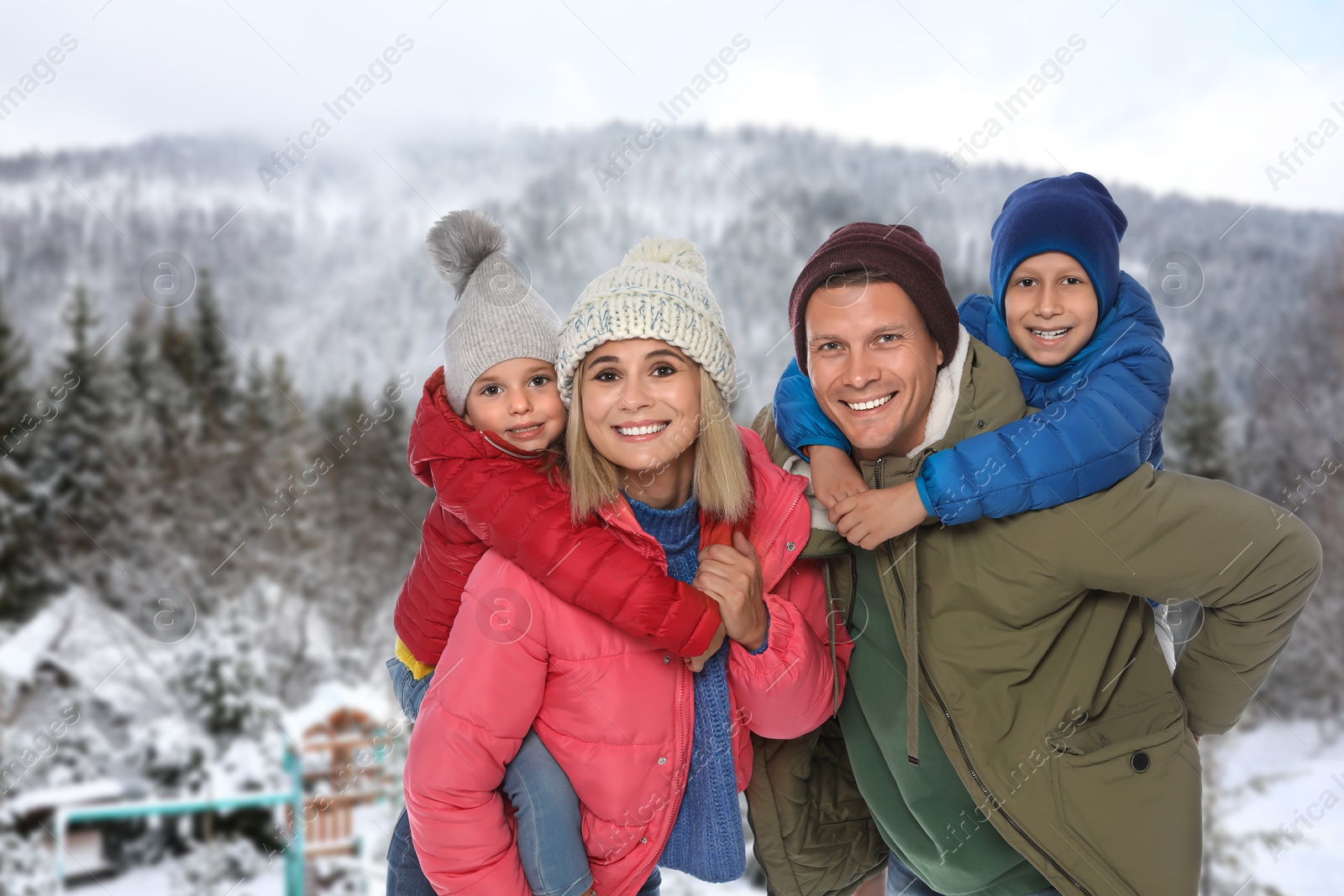 Image of Portrait of happy family with children in mountains on winter day