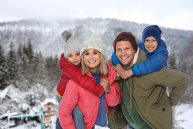 Portrait of happy family with children in mountains on winter day