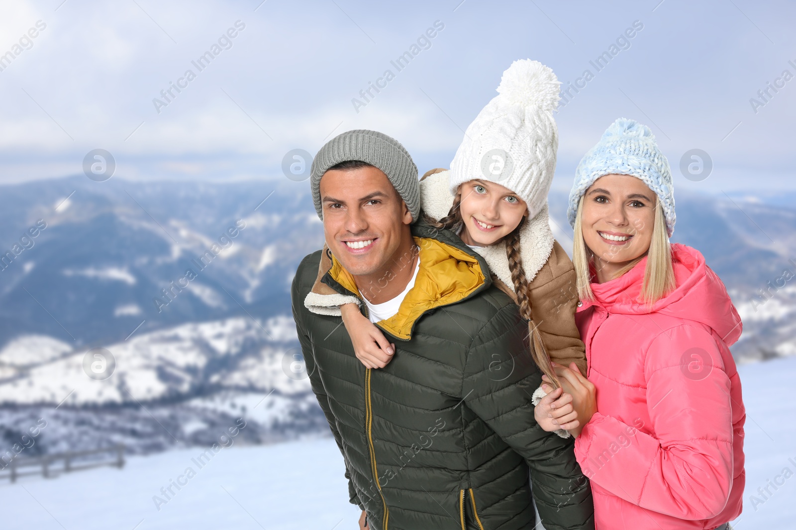 Image of Portrait of happy family with child in mountains on winter day