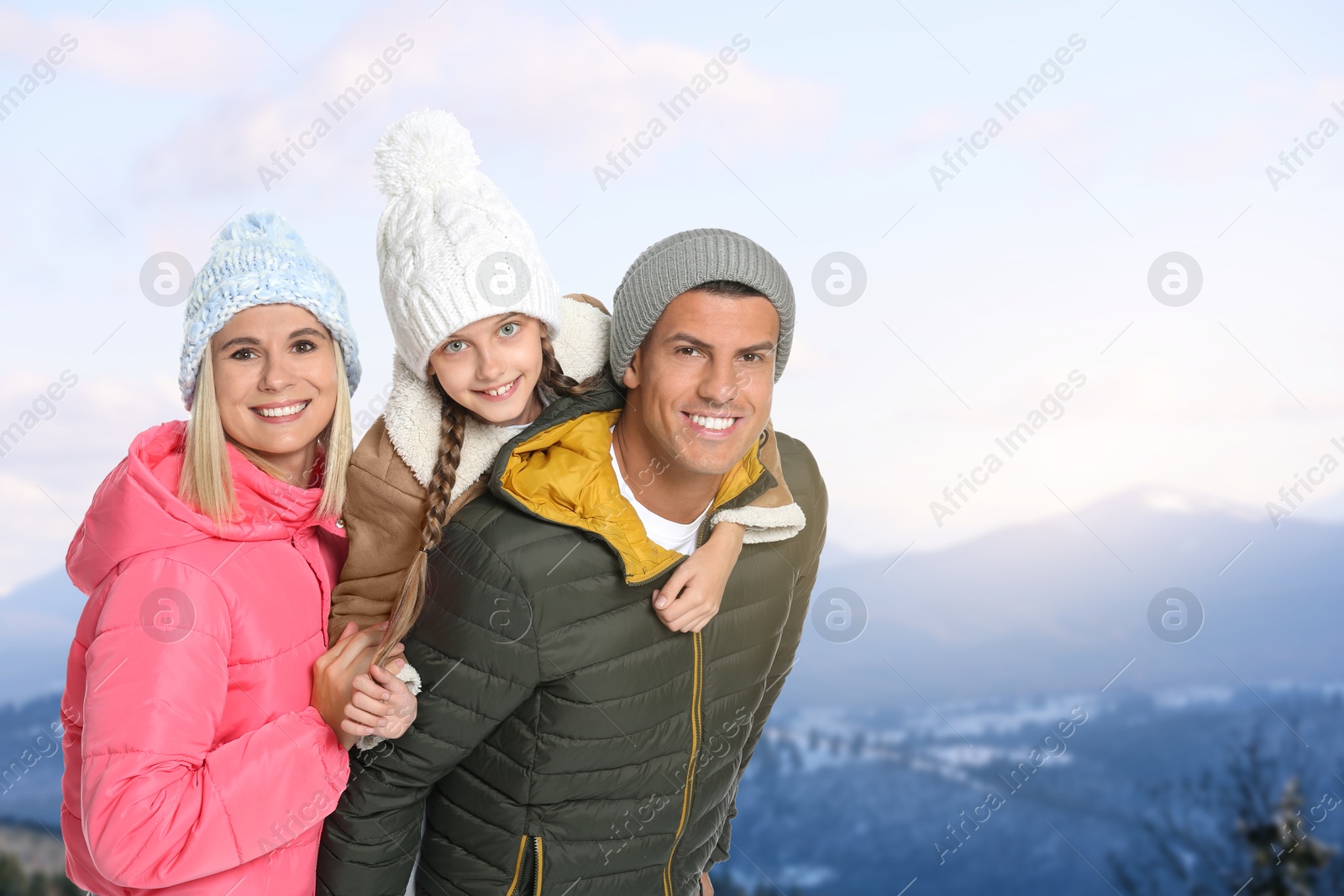 Image of Portrait of happy family with child in mountains on winter day